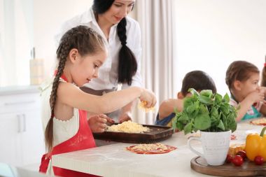 Çocuk ve öğretmen sınıfları pişirme sırasında mutfakta