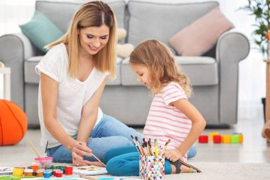 Anne ile kızı kapalı yerde otururken boyama