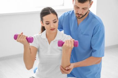 Fizyoterapist klinikte genç bayan hasta ile çalışma