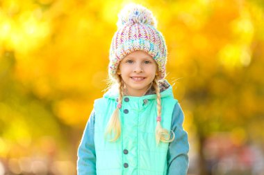 Sonbahar parkında küçük şirin bir kız.