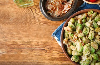 Kavrulmuş Brussel lahanası ve ahşap masa üzerinde pastırma ile kase