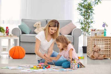 Anne ile kızı kapalı yerde otururken boyama