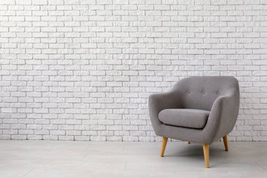 Tuğla duvarın yanındaki rahat koltuk