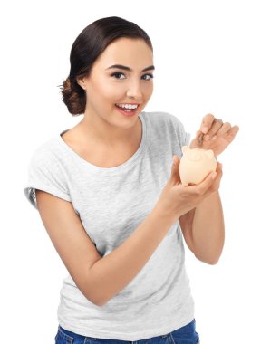 Genç kadın kumbara beyaz arka plan üzerinde içine para koyarak