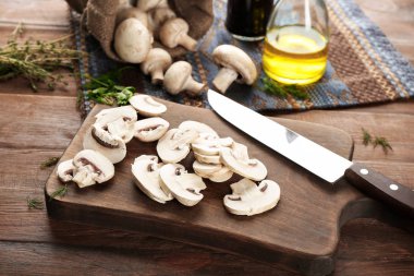 Ahşap tahta üzerinde taze dilimlenmiş champignon mantar