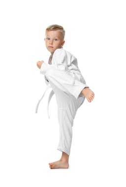 Küçük çocuk beyaz arka planda karate yapıyor.
