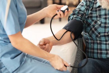 Genç caregiver komuta sizde, closeup kan basıncı ölçme
