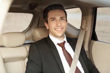 Adam arabanın arka koltuk üzerinde formal giyim