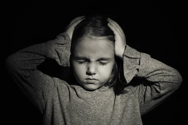 Маленькая грустная девочка на черном фоне. Злоупотребление детской концепцией — стоковое фото