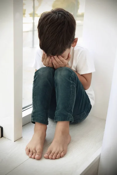 Um rapaz triste a chorar em casa. Conceito de abuso de crianças — Fotografia de Stock