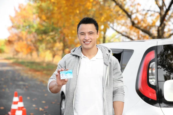 若い男の車の近くの運転免許証を保持しています。 — ストック写真