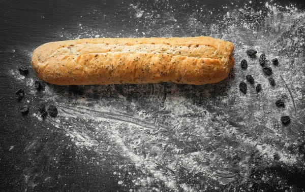 Yummy roti segar dan kismis pada latar belakang gelap — Stok Foto