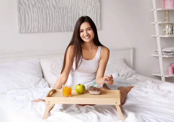 Mladá žena s snídaně v posteli doma — Stock fotografie