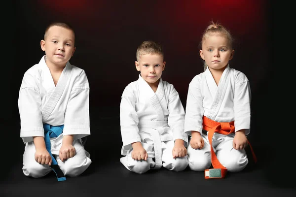 Niños pequeños en karategi sobre fondo oscuro — Foto de Stock