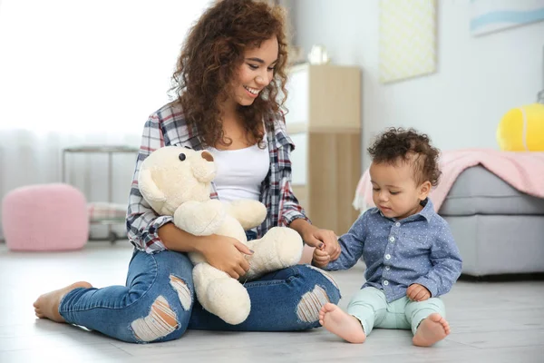 Mignon bébé et mère assis sur le sol à la maison — Photo