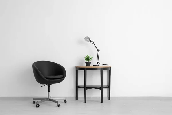 Cómodo sillón y mesa cerca de la pared de luz — Foto de Stock