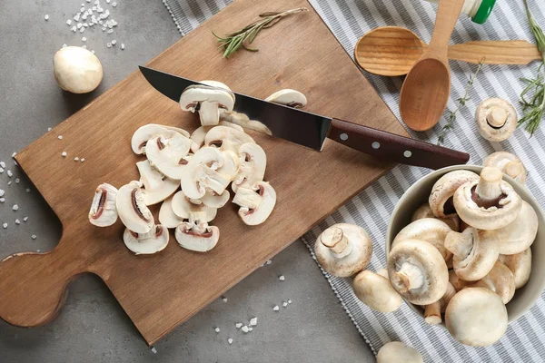 Ahşap tahta üzerinde taze dilimlenmiş champignon mantar — Stok fotoğraf