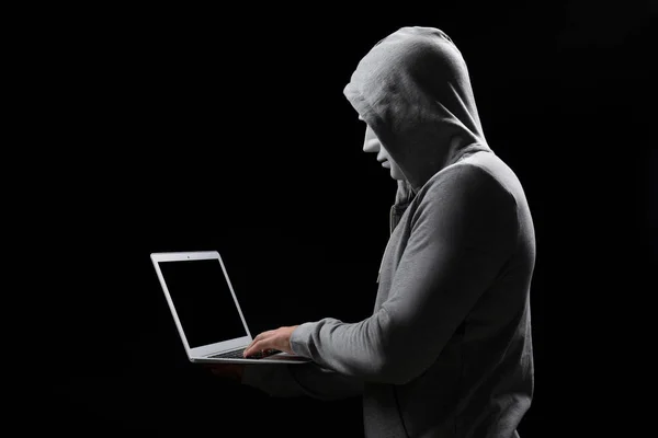 Hacker in mask with laptop on dark background — Stock Photo, Image