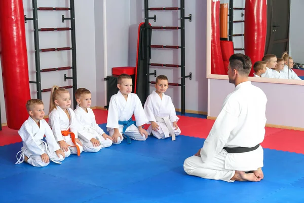 Instructor de karate masculino con niños pequeños en dojo —  Fotos de Stock