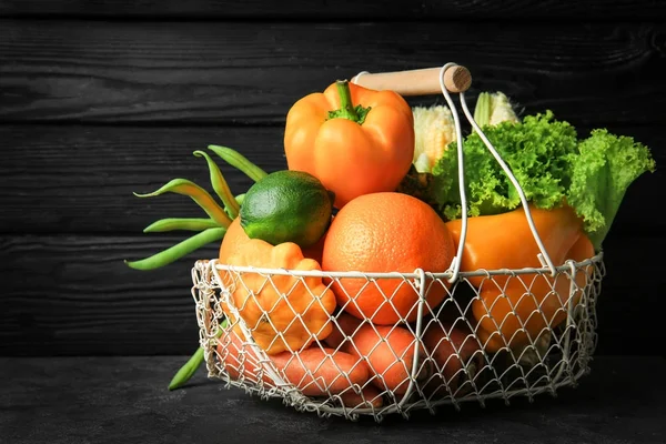 Mand met verschillende groenten en fruit tegen donkere houten achtergrond — Stockfoto