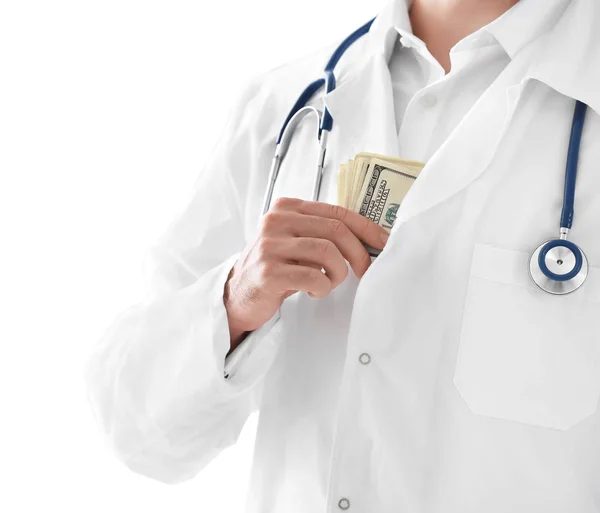 Doutor colocando dinheiro no bolso no fundo branco. Conceito de corrupção — Fotografia de Stock