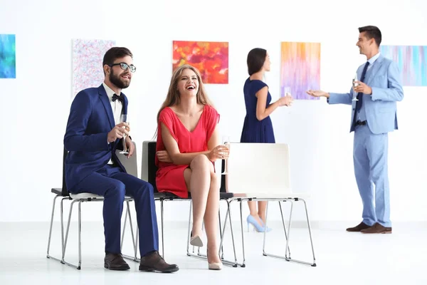 Jovem casal em desgaste formal na galeria de arte exposição — Fotografia de Stock