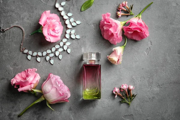 Összetétele üveg Parfüm és a virágok, a szürke háttér — Stock Fotó