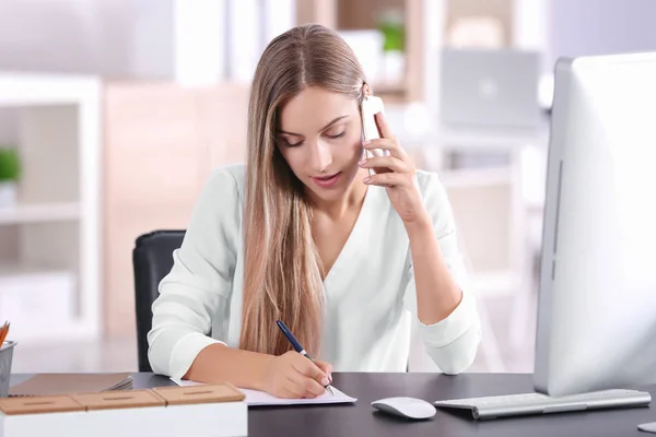 Młoda kobieta rozmawia przez telefon w biurze — Zdjęcie stockowe