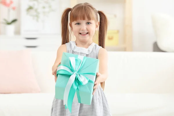 Liten flicka håller presentförpackning för mors dag hemma — Stockfoto