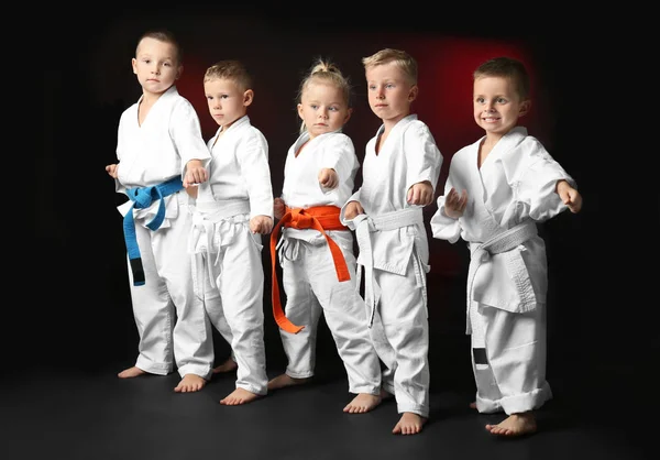 Little children practicing karate on dark background — Stock Photo, Image