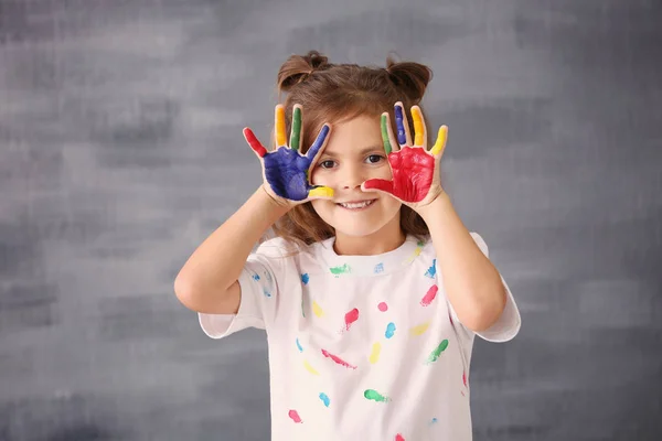 Little girl with painted hands on grey background — Stock Photo, Image