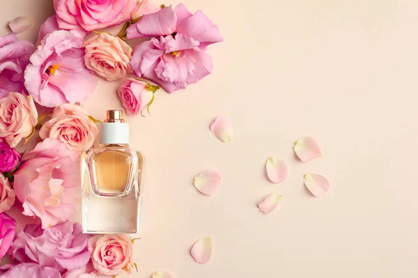 Garrafa de perfume com flores no fundo claro — Fotografia de Stock