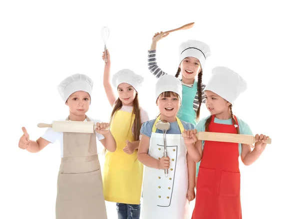Милі діти в фартухах з кухонним посудом на білому тлі — стокове фото