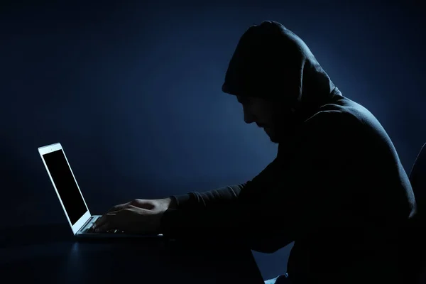Hacker usando laptop no fundo escuro — Fotografia de Stock