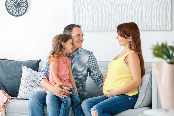 Happy young family on sofa at home