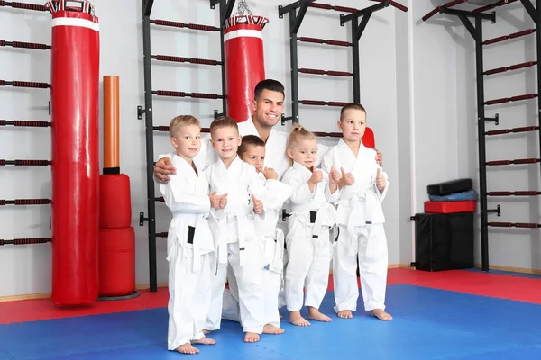 Instrutor de karatê masculino com crianças pequenas no dojo — Fotografia de Stock