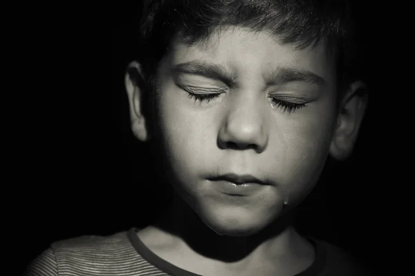 Pequeno menino triste chorando no fundo preto. Conceito de abuso de crianças — Fotografia de Stock