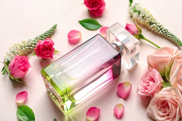 Flasche Parfüm mit Blumen auf hellem Hintergrund — Stockfoto