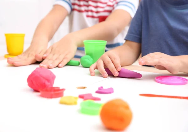 Crianças pequenas envolvidas em modelagem de massa de brincar na creche, close-up — Fotografia de Stock