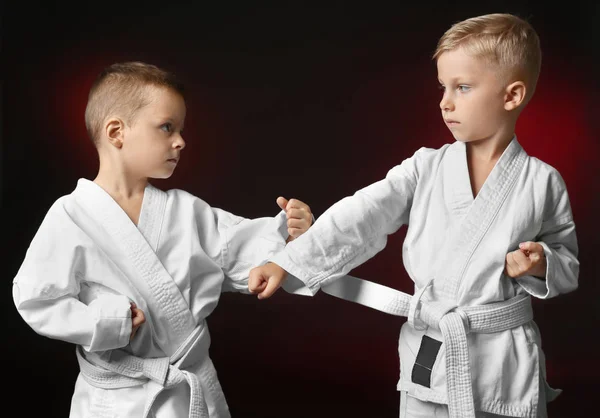 Küçük çocuk karate koyu arka plan üzerinde pratik — Stok fotoğraf