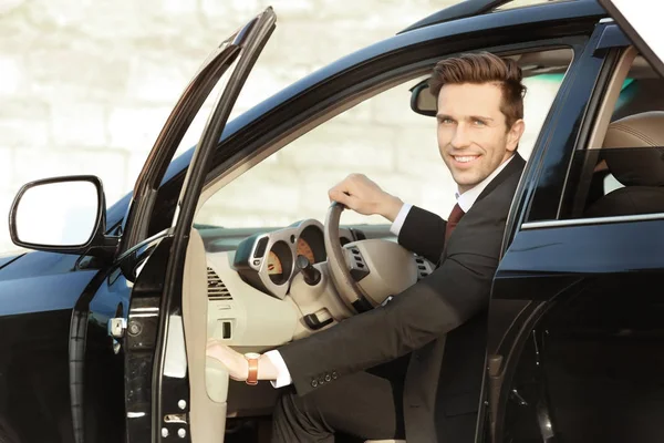 Man in formal wear getting out of car — Stock Photo, Image