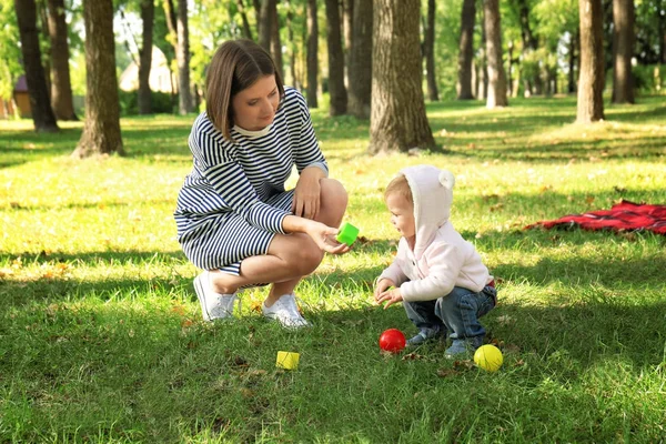 Moeder met schattig meisje samenspelen in herfst park — Stockfoto