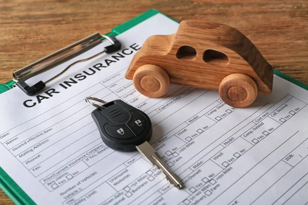 Composition with wooden auto and car insurance on table — Stock Photo, Image