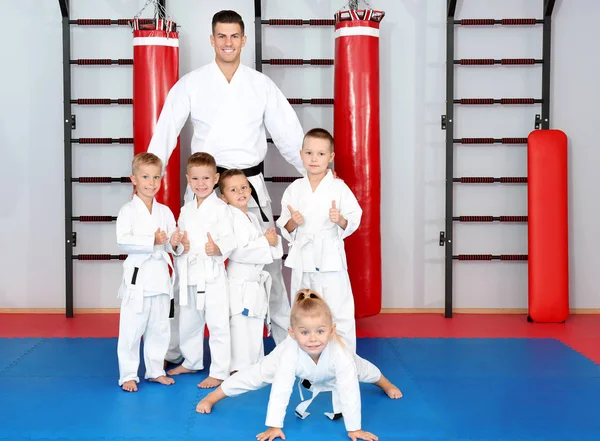 Instructor de karate masculino con niños pequeños en dojo — Foto de Stock