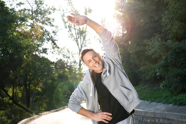 Volwassen sportieve man warming-up voordat u buitenshuis — Stockfoto