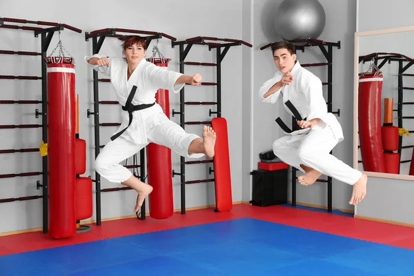 Młody mężczyzna i kobieta ćwiczyć karate w dojo — Zdjęcie stockowe