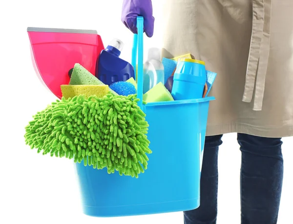Woman holding bucket with cleaning products and tools on white background — Stock Photo, Image