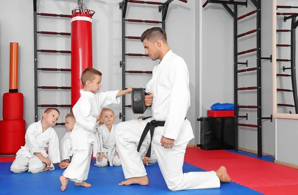 Instructeur de karaté masculin formant un petit garçon au dojo — Photo