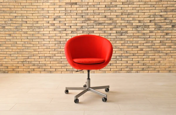 Comfortable armchair near brick wall — Stock Photo, Image