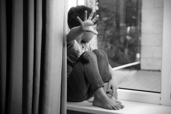 Helpless little boy near window. Abuse of children concept — Stock Photo, Image